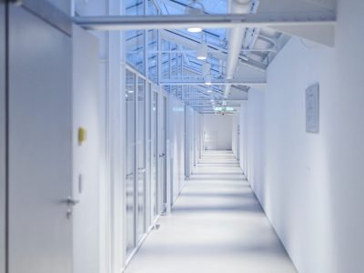 a long hallway with white walls and a skylight